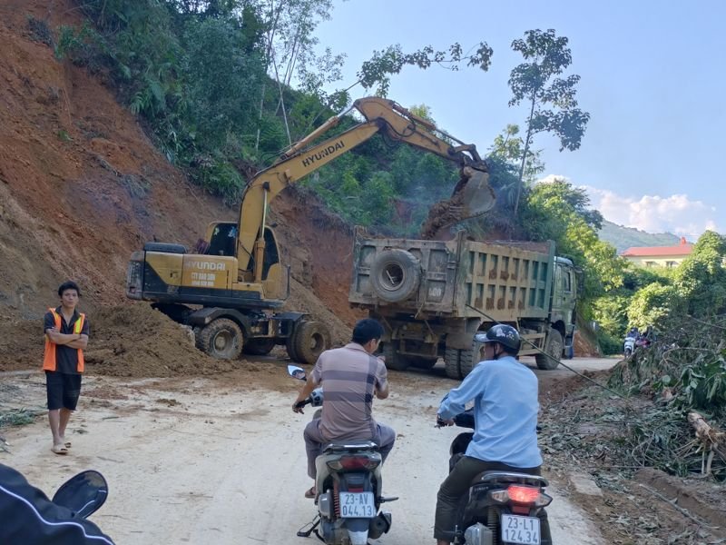 An excavator removing a landslide on the road