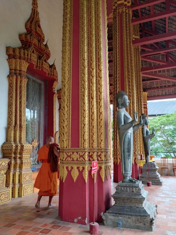 A monk at the entrance of the sim of Wat Haw Pha Kaeo