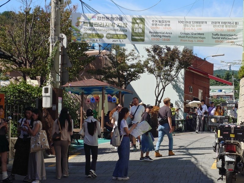 Tourists walking along a street and entering Gangseom
