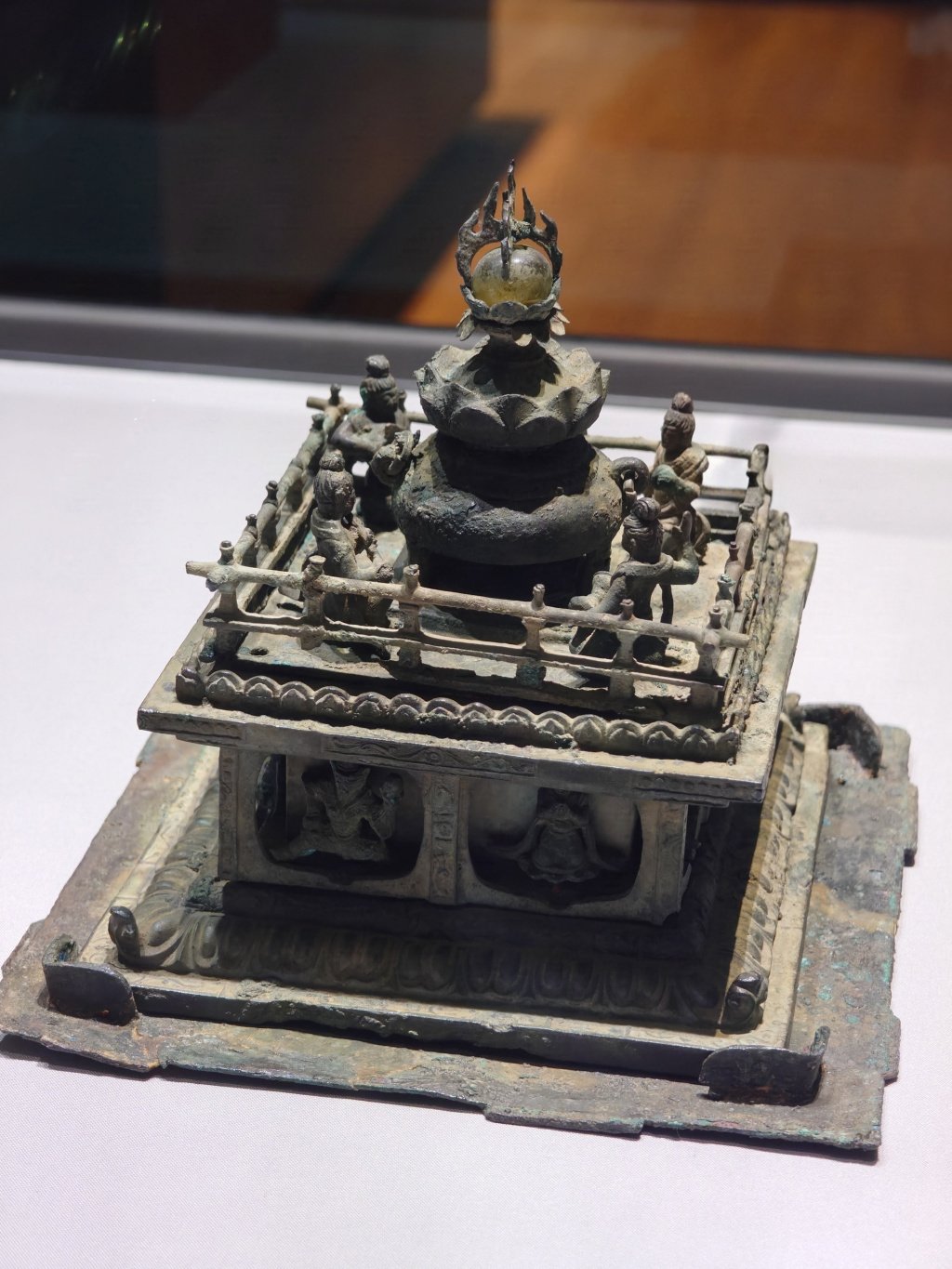 A bronze Silla container in the shape of a square temple with musicians around the four corners